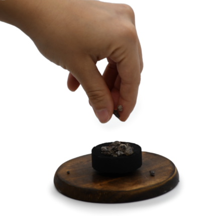 mano colocando resina para quemar copal