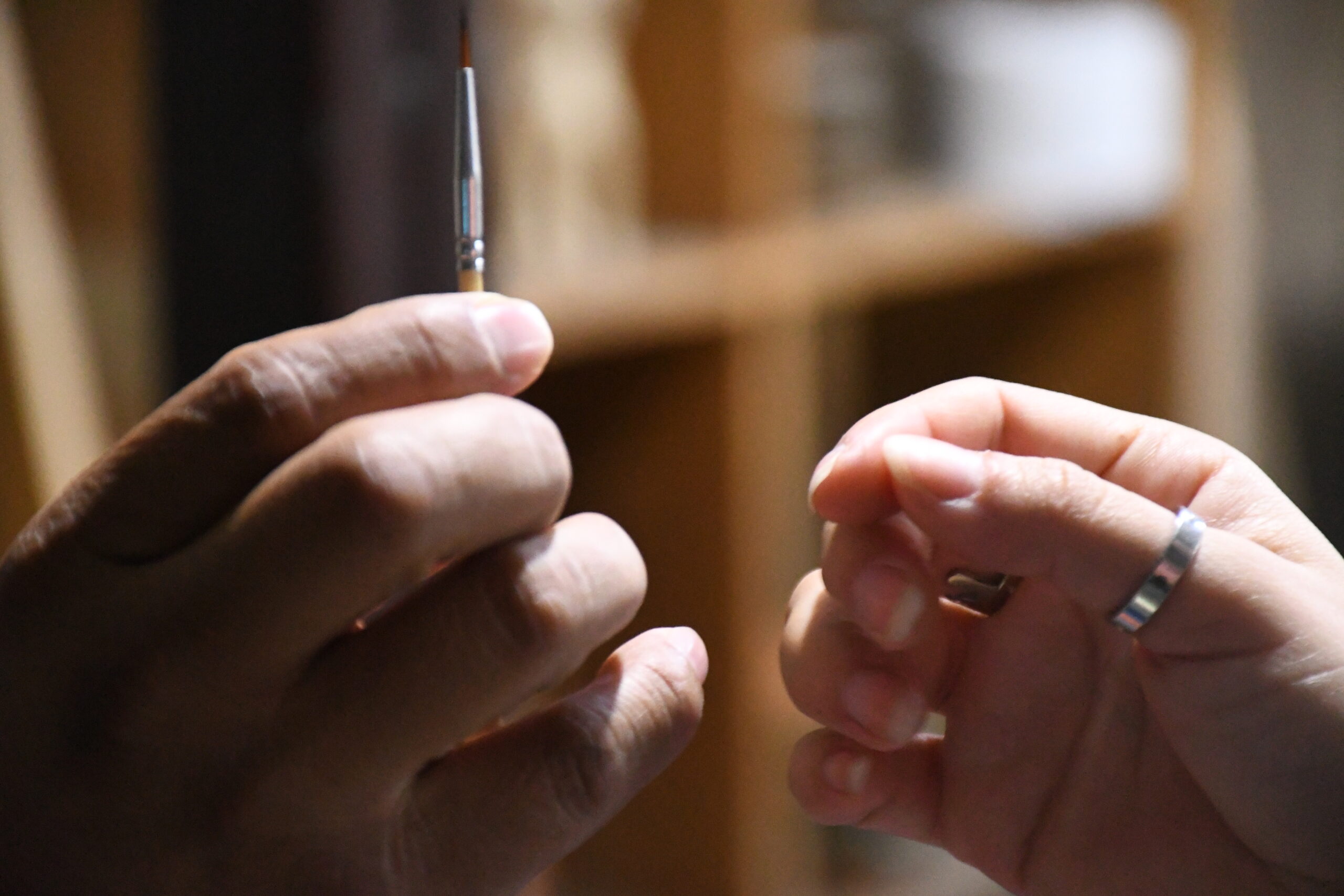 Mano entregando un pincel